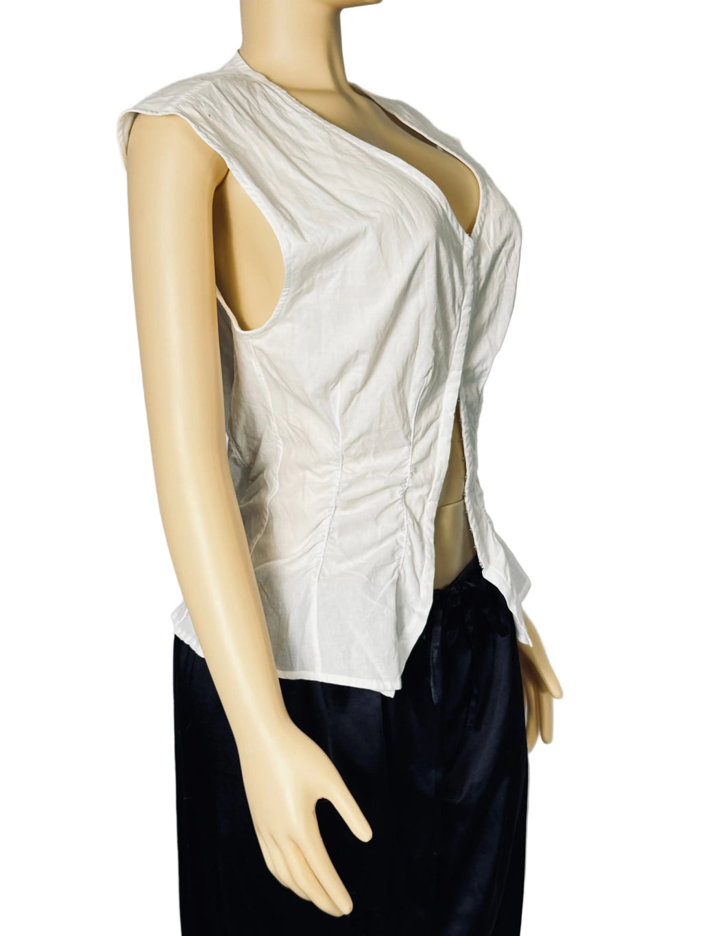 A sleeveless white wrap-style top with a deep V-neck and side slit, displayed on a beige mannequin torso against a light gray backdrop. The mannequin is also wearing dark navy bottoms.