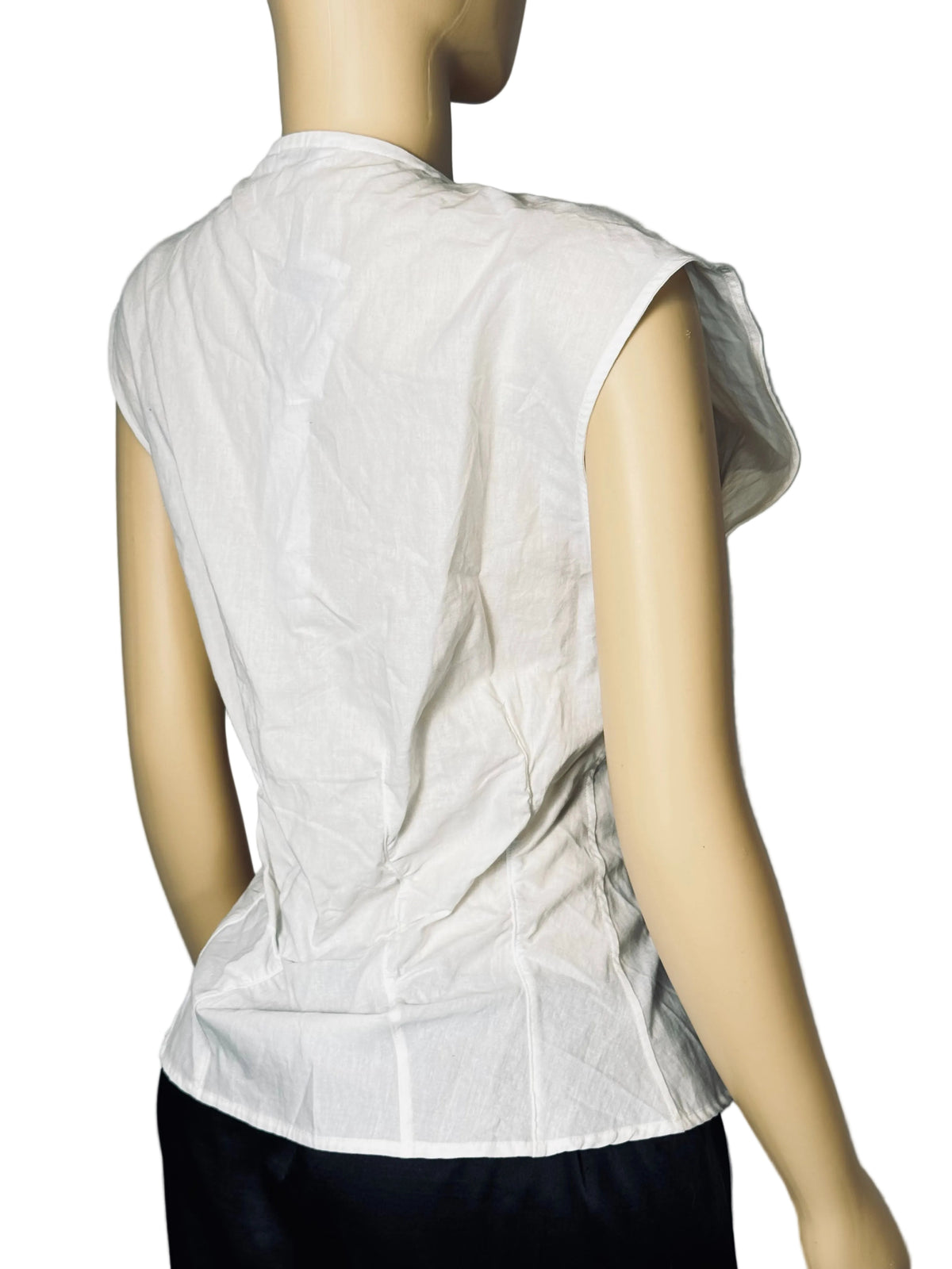 A sleeveless white top with a high collar, shown from the back on a mannequin. The mannequin is also wearing dark bottoms, set against a light gray textured backdrop.