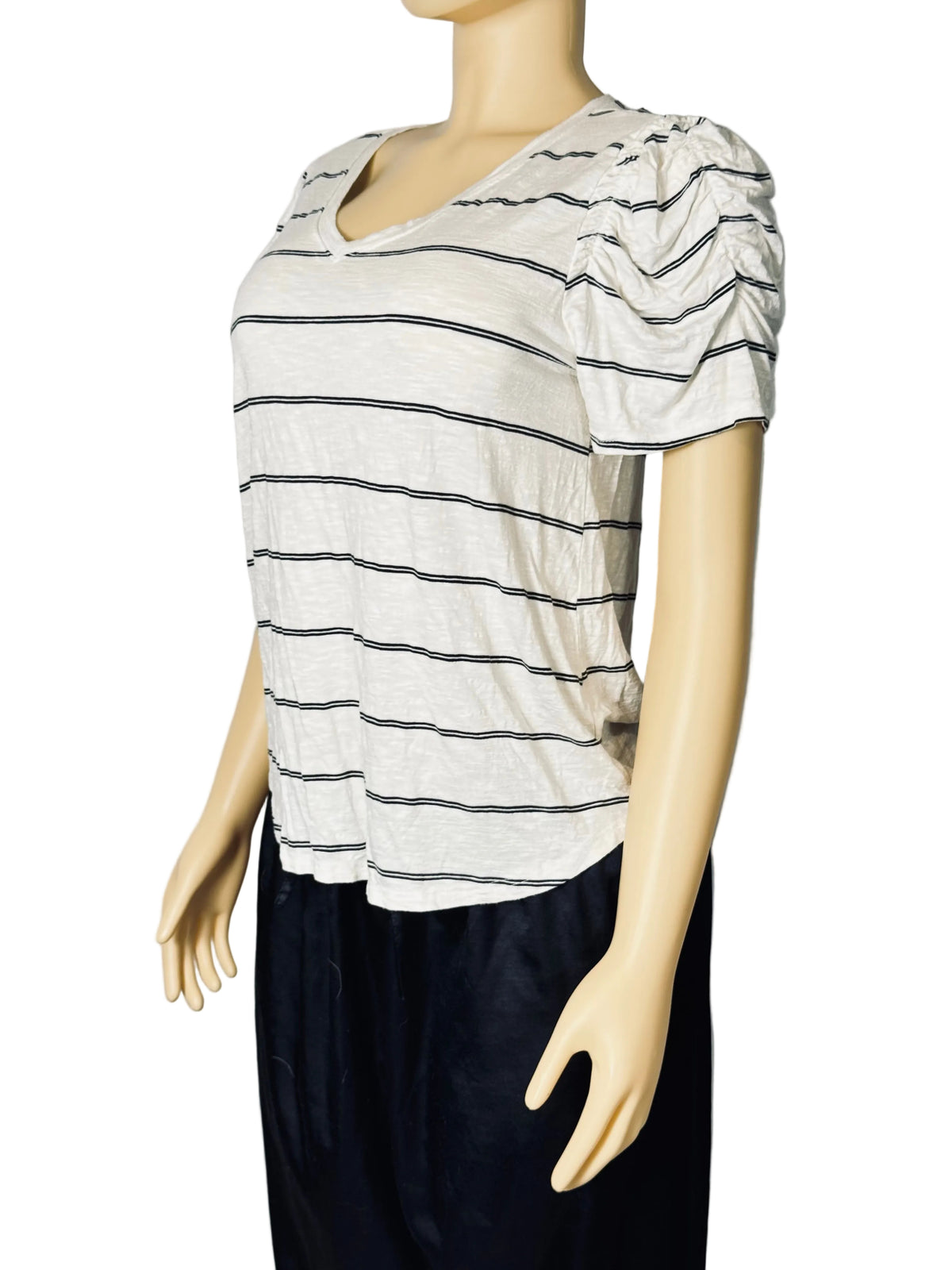 A short-sleeve V-neck top with horizontal dark gray stripes on an off-white base, displayed on a beige mannequin torso with dark navy bottoms against a light gray backdrop.