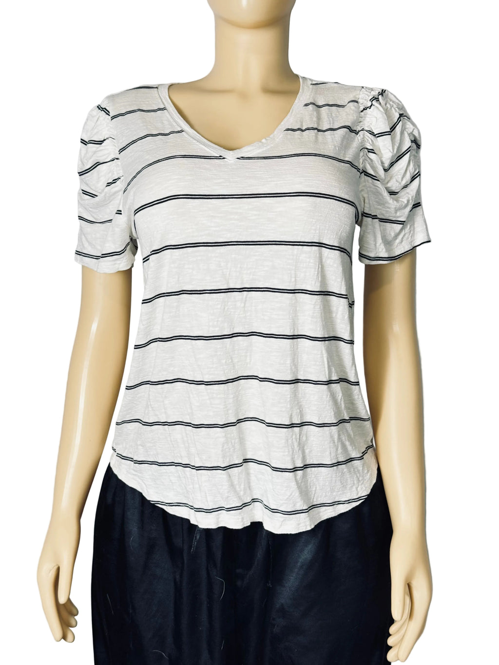 A women's short-sleeve V-neck top with thin horizontal black stripes on a light gray or off-white base, displayed on a mannequin. The top features puffed short sleeves and a relaxed fit, paired with dark bottoms.
