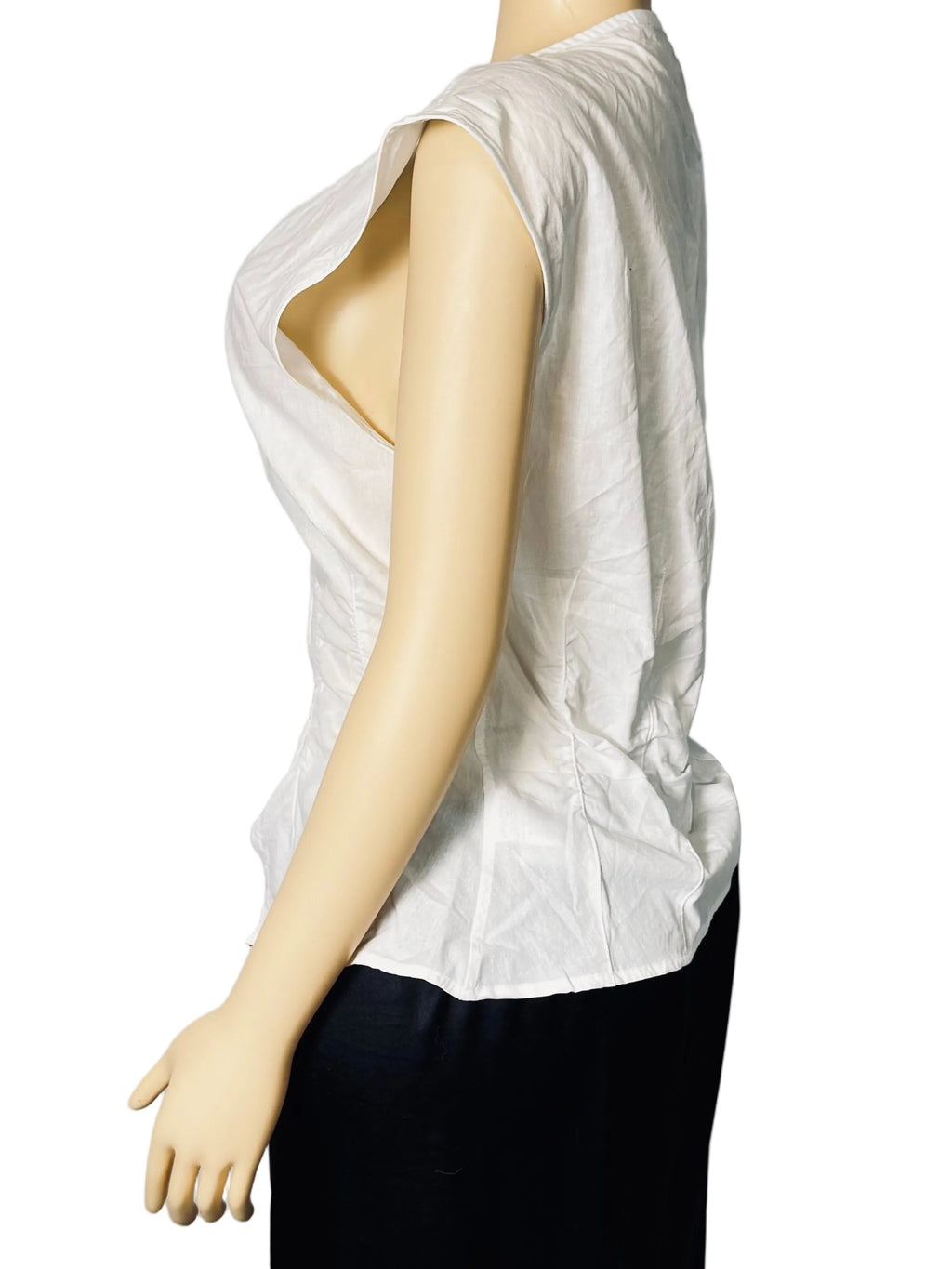 A sleeveless white top with a dramatic plunging neckline, displayed on a beige mannequin from the side against a white fabric backdrop.