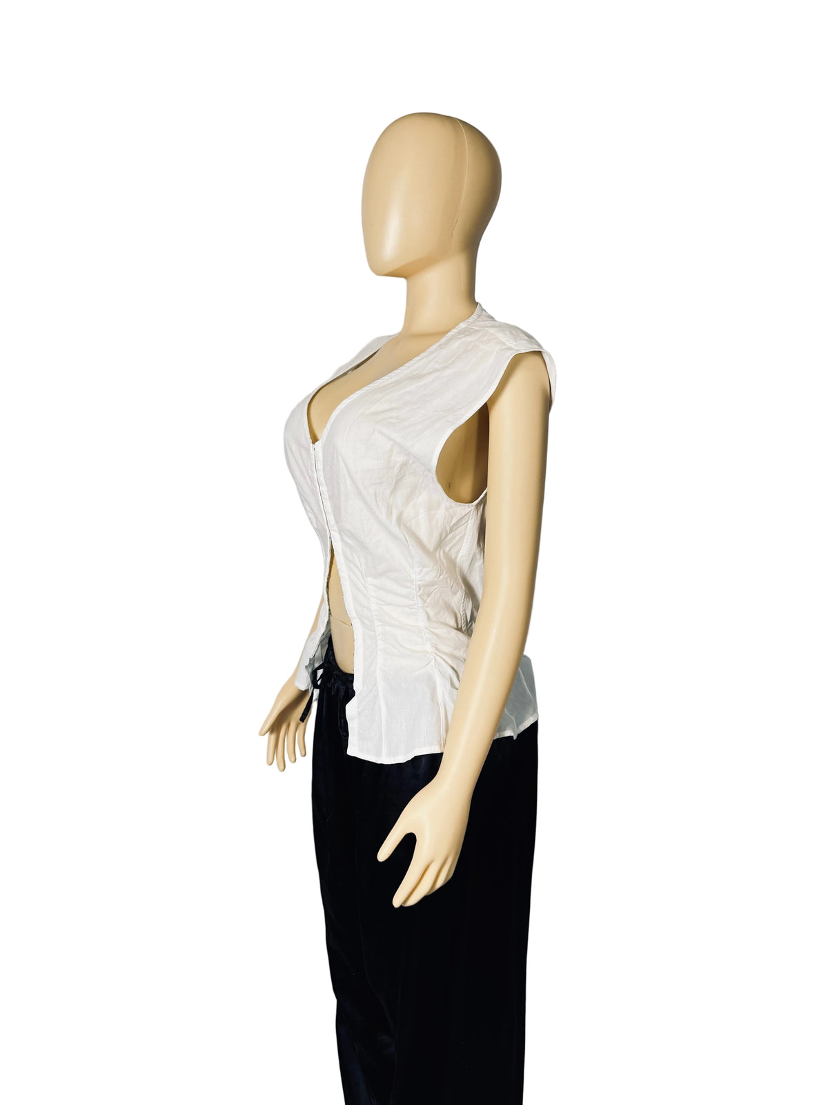 A sleeveless white top with a deep plunging neckline and side cutouts, displayed on a beige mannequin torso against a white fabric backdrop.